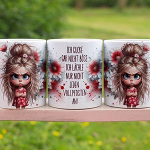 Puede incluir: Tres tazas de cerámica blanca con una ilustración de dibujos animados de una niña enfadada con un vestido rojo. Las tazas tienen el texto "ICH GUCKE GAR NICHT BÖSE, ICH LÄCHLE NUR NICHT JEDEN VOLLPFOSEN AN!" y adornos florales.