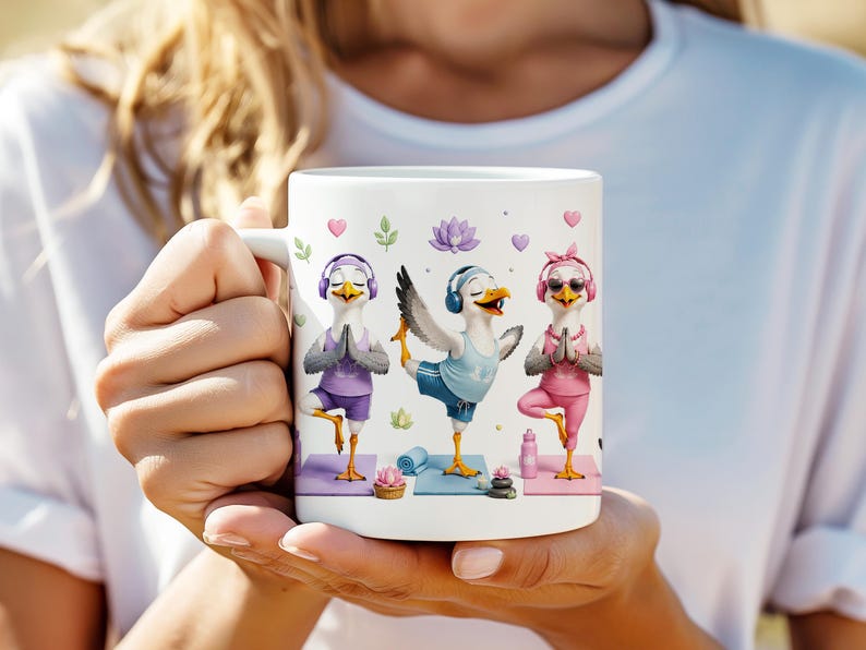 May include: A white ceramic mug featuring a graphic illustration of three seagulls performing yoga poses. The seagulls wear colorful athletic clothing, headphones, and sunglasses, while practicing on individual mats with lotus flowers and water bottles.