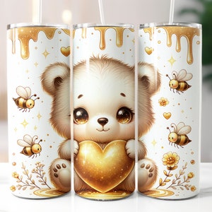 Puede incluir: Un vaso blanco con un lindo oso de dibujos animados sosteniendo un corazón dorado. El fondo es blanco con miel dorada que gotea, estrellas y abejas.