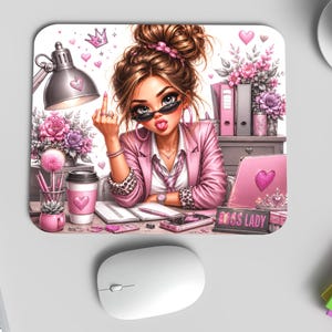 Peut inclure: Tapis de souris rose avec une illustration de dessin animé d'une femme en blazer rose, lunettes de soleil et chignon. Le tapis de souris présente une scène de bureau avec un ordinateur portable, une tasse à café et le texte "BOSS LADY".