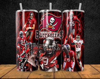 May include: Three stainless steel tumblers with a red, black, and white design featuring the Tampa Bay Buccaneers logo and various players. The tumblers have a lightning bolt pattern and the words "Tampa Bay Buccaneers" are printed on the middle tumbler.