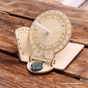 May include: A wooden sundial with a compass, featuring a circular dial with numbers and Chinese characters. The sundial is labelled "Northern Hemisphere" and includes a small compass at the base. The design is intricate and detailed.