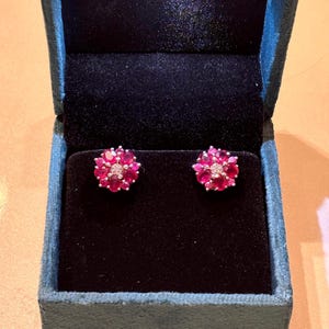 May include: A pair of ruby and diamond flower stud earrings in a velvet jewellery box.