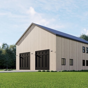 May include: A modern two-story building with a light beige exterior and a dark gray roof. The building has two large black garage doors and several black windows. The structure is set on a green lawn with trees in the background.