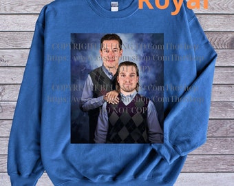 May include: A royal blue sweatshirt with a printed image of two men standing together. The image is set against a blue and white cloudy background. The text "COPYRIGHT BELONG TO Com The Shop hups: ww.elszáróm shop Com The Shop KBL Com Thong NOT COP" is printed on the image.