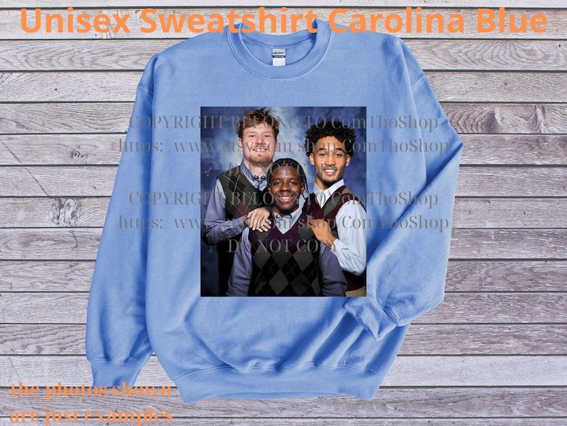 May include: Carolina blue unisex sweatshirt with a crew neck. The sweatshirt features a group photo of three people. The text "Unisex Sweatshirt Carolina Blue" is printed at the top of the image.