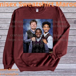 May include: Maroon unisex sweatshirt with a printed image of three people. The sweatshirt has long sleeves and a crew neck. The text "Unisex Sweatshirt Maroon" is at the top of the image. The image also contains the text "COPYRIGHT BIO TO Com ThoShop" and "https://www.yomshop.com ThoShop".