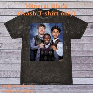 May include: Mineral black t-shirt with a graphic of three people wearing argyle vests. The text "Mineral Black (wash T-shirt only)" is at the top. The shirt has a distressed look.