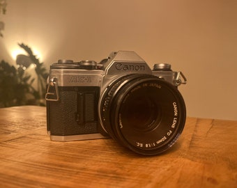 Canon AE-1 with Canon FD 50mm f1.8 lens, 28mm f2.8 lens and 135mm f2.8 lens + metal case and flash