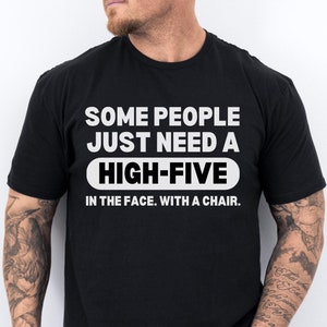 May include: Black t-shirt with white text that reads "Some people just need a high-five in the face. With a chair."