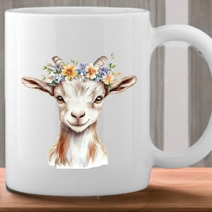 May include: White ceramic mug with a watercolor illustration of a goat wearing a flower crown. The goat has brown fur and a white face. The flowers in the crown are yellow, blue, and purple.