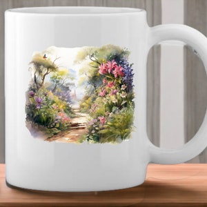 May include: White ceramic mug with a watercolor design of a garden path lined with pink, purple, and white flowers. The path leads to a small building in the distance.