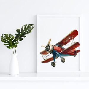 Op de afbeelding: Een ingelijste print van een rode en blauwe vintage biplane die tegen een witte achtergrond vliegt.