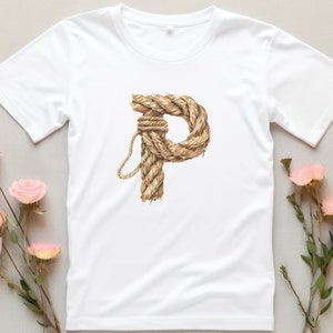 May include: White t-shirt with a rope design in the shape of the letter "P".