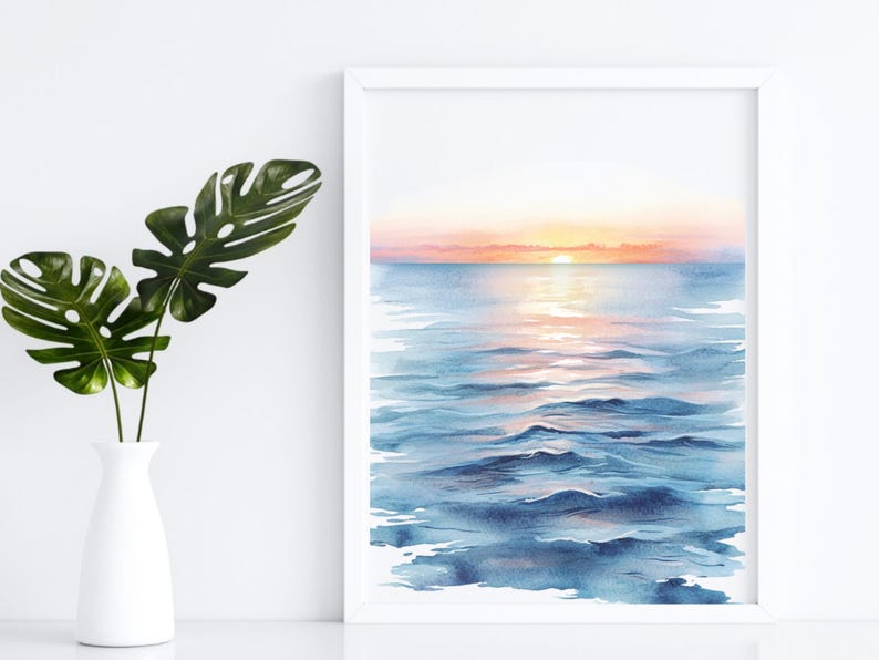 K&ouml;nnte beinhalten: Ein Aquarellgem&auml;lde eines Sonnenuntergangs &uuml;ber dem Meer. Das Wasser ist tiefblau mit einem Hauch von Rosa und Orange von der untergehenden Sonne. Der Himmel ist zartrosa und orange.