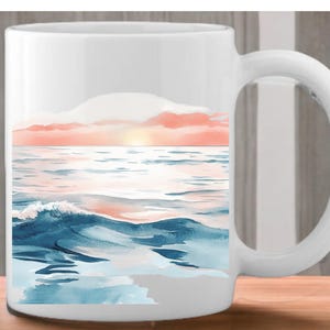 K&ouml;nnte beinhalten: Wei&szlig;e Keramiktasse mit einem Aquarellbild eines Sonnenuntergangs &uuml;ber dem Meer. Das Bild zeigt blaue Wellen, einen rosa und orangenen Himmel und eine strahlend gelbe Sonne.