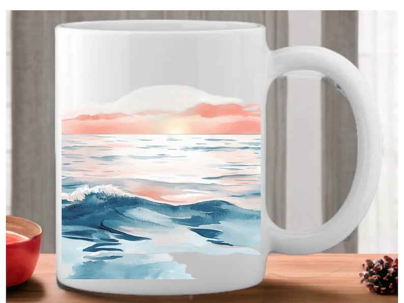 K&ouml;nnte beinhalten: Wei&szlig;e Keramiktasse mit einem Aquarellbild eines Sonnenuntergangs &uuml;ber dem Meer. Das Bild zeigt blaue Wellen, einen rosa und orangenen Himmel und eine strahlend gelbe Sonne.
