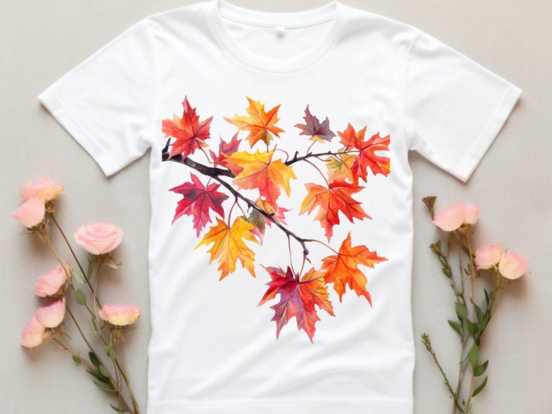 K&ouml;nnte beinhalten: Wei&szlig;es T-Shirt mit einem Aquarell-Design eines Zweigs mit Herbstbl&auml;ttern in Rot-, Orange- und Gelbt&ouml;nen.