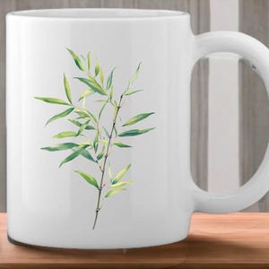 May include: White ceramic mug featuring a green bamboo plant design. The mug has a handle on the right side.
