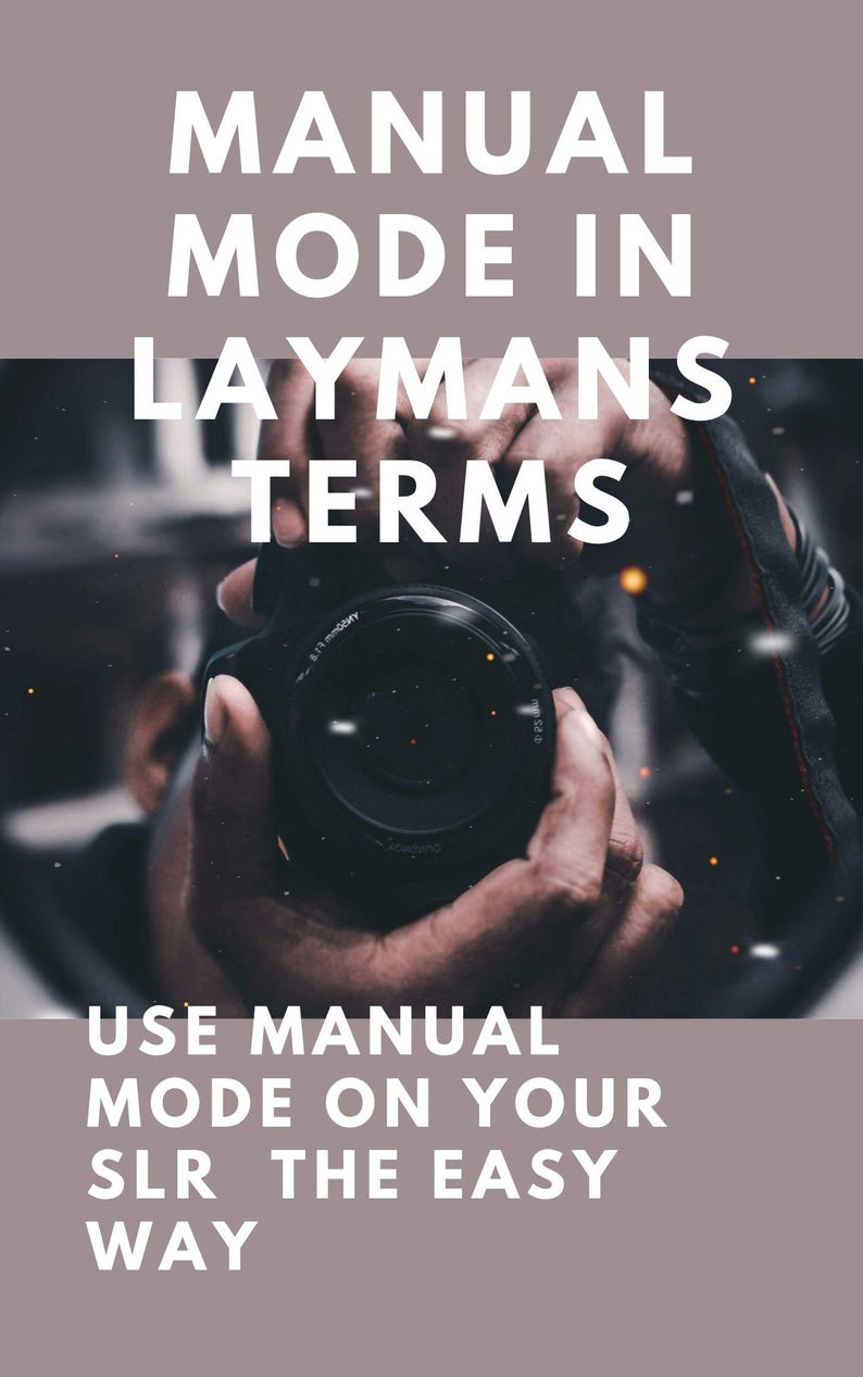 May include: Image with text: "MANUAL MODE IN LAYMANS TERMS" and "USE MANUAL MODE ON YOUR SLR THE EASY WAY." A person is holding a black camera, with the lens facing the viewer. The background is blurred, with a muted color palette.