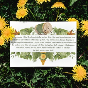 May include: A white card with text, a drum illustration, and green leaf accents, set against a backdrop of green grass and yellow dandelions. The card's text invites players to a garden treasure hunt.