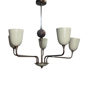 Puede incluir: Una l&aacute;mpara de ara&ntilde;a de estilo retro con cinco pantallas en forma de tulip&aacute;n de color blanco roto. La l&aacute;mpara tiene brazos y un v&aacute;stago de color bronce, una esfera de madera oscura y una peque&ntilde;a base decorativa. El dise&ntilde;o es minimalista y elegante.