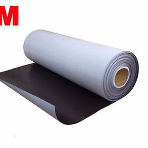 May include: A roll of magnetic sheeting with a white backing. The sheeting is rolled up and the white backing is visible. The sheeting is labelled with the 3M logo.