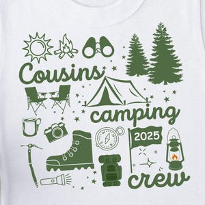 Puede incluir: Camiseta blanca con un diseño verde con temática de camping. El diseño incluye un sol, una fogata, binoculares, árboles, sillas, una tienda de campaña, una taza, una cámara, una bota, una brújula, una mochila, una bandera con "2025", una linterna y las palabras "Cousins camping crew".