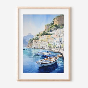 May include: Watercolor painting of a colorful Italian village on a cliffside overlooking a harbor with boats. The water is a deep blue and the sky is a light blue. The buildings are white with colorful accents.