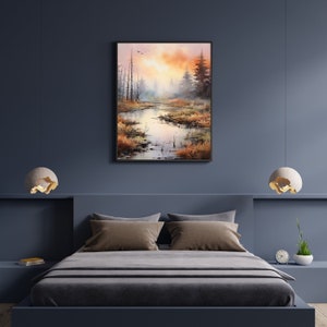 May include: A watercolor painting of a misty forest scene with a river winding through the trees. The sky is a soft orange and pink, and the trees are a muted green and brown. The painting is framed in a black frame.