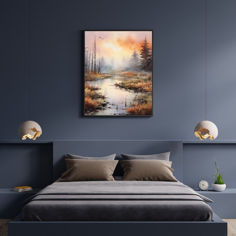 May include: A watercolor painting of a misty forest scene with a river winding through the trees. The sky is a soft orange and pink, and the trees are a muted green and brown. The painting is framed in a black frame.