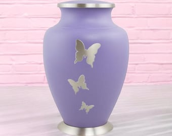 May include: A lavender metal urn with a silver butterfly design. The urn has a silver lid and base.