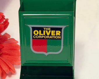 Green matchbox/matchstick metal dispenser with the Oliver Corp. logo.