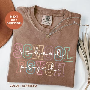 a t - shirt that says school psychh next to a pair of scissors