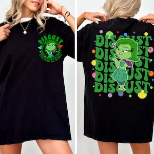 May include: Black t-shirt with a green cartoon character on the front and the text "DISGUST It's OK to Feel All the Feels". The back of the shirt has the word "DISGUST" repeated in a circle with colorful dots.