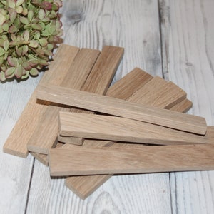 May include: A pile of light brown wooden strips, likely for crafting or woodworking projects.