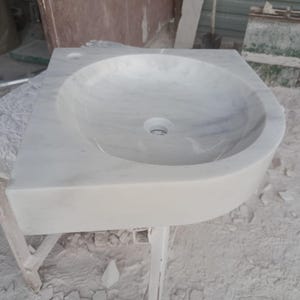 "Hand-carved Carrara marble sink – elegant, durable, and timeless. Perfect for luxury bathrooms, powder rooms, and boutique interiors. Custom sizes available: wall-mounted or countertop installation. Each piece features unique natural veining, adding character to your space. Discover our full collection of marble sinks, bathtubs, and stone accessories at MarbleSinkCo – follow us for more exclusive designs."