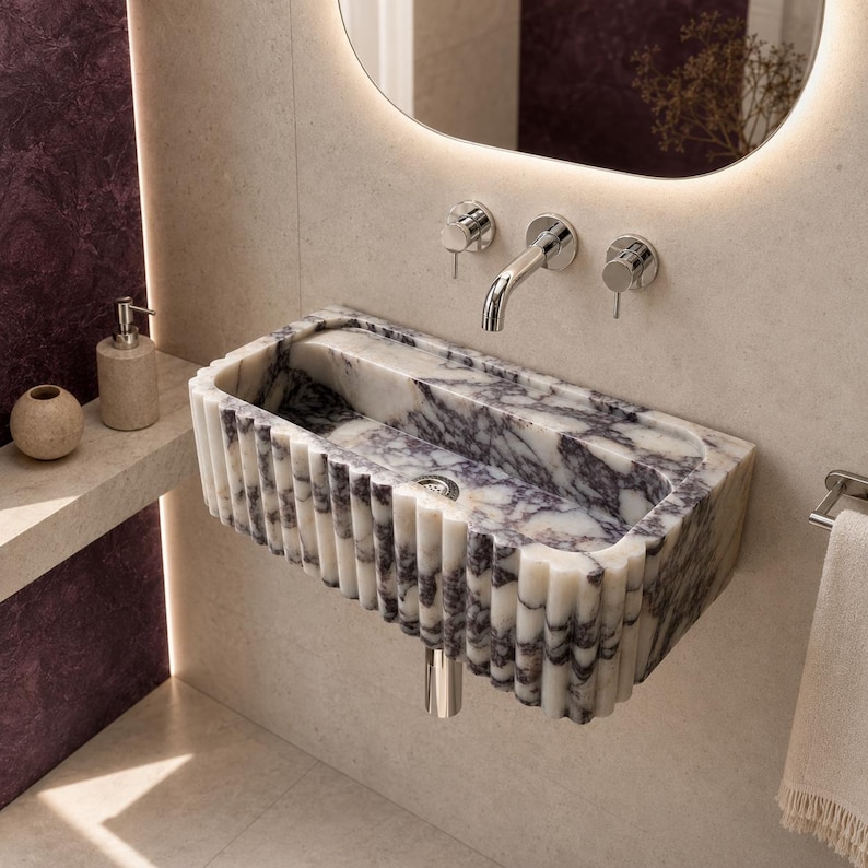 Fluted Calacatta Viola marble sink wall mounted in an ultra-luxury bathroom with polished chrome faucet and modern accessories.