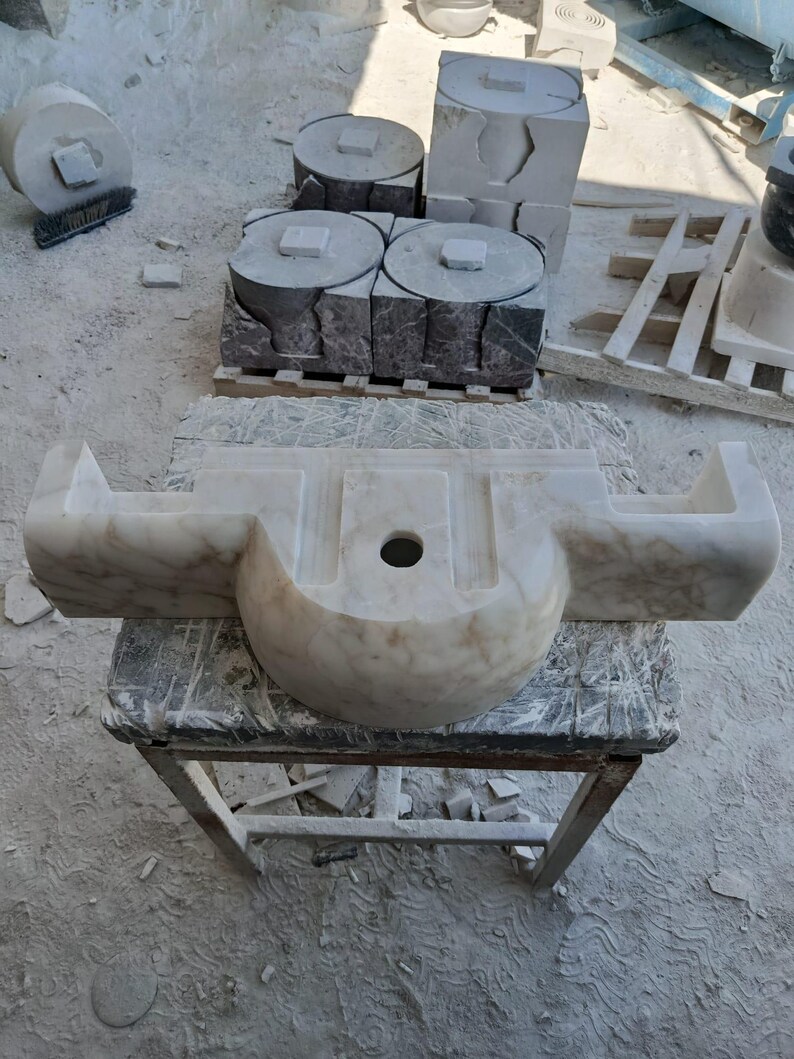 Luxurious wall-mounted Calacatta marble sink carved from a single block. Featuring 3 faucet holes, fluted front design, and floating vanity look. Ideal for modern, minimalist bathrooms. Custom sizes available. Handmade from natural Italian stone. Bathroom sink, marble vanity, stone basin, designer sink, fluted marble, wall mount sink, handmade sink, rectangular sink, luxury bathroom decor.