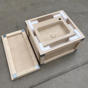 Travertine wall sink protected with foam inside a reinforced wooden export shipping crate
