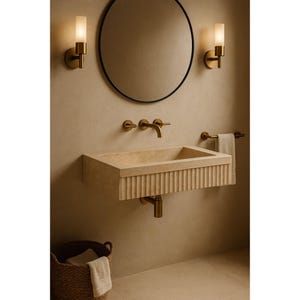 Handmade travertine wall-mounted sink with fluted front and matte finish. Custom sizes available. Ideal for luxury bathrooms, hotels, interior designers, and modern spa spaces. Each basin is carved from solid stone. Ships globally in a wooden crate via DHL Express. Natural veining varies uniquely in each piece.Perfect for minimalist,rustic,and architectural interiors, travertine wall-mounted sink,fluted front, solid stone, custom sizes,interior designers, modern spa, luxury bathrooms, minimalist