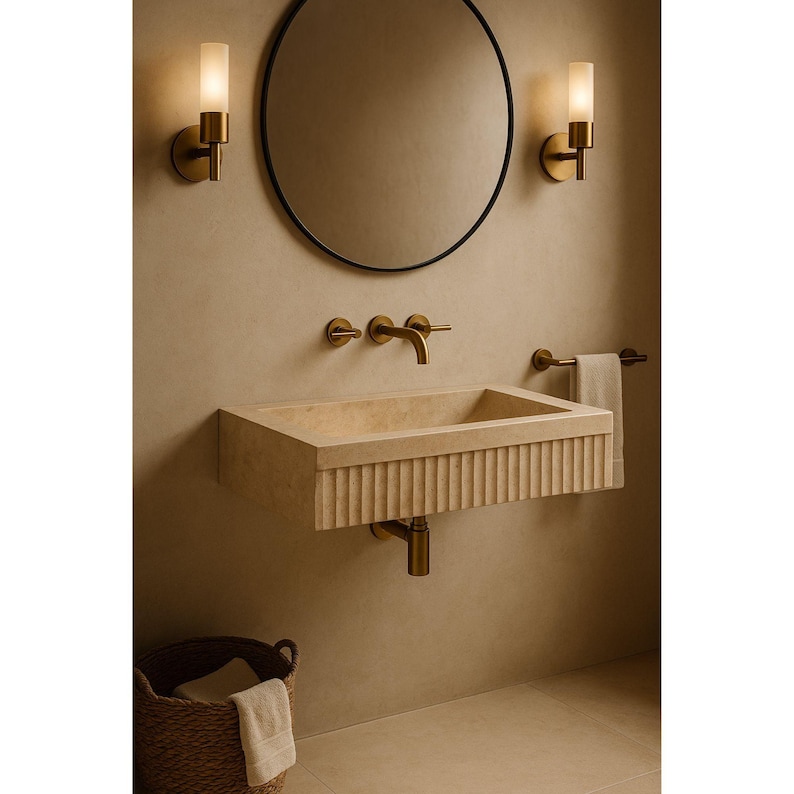 Handmade travertine wall-mounted sink with fluted front and matte finish. Custom sizes available. Ideal for luxury bathrooms, hotels, interior designers, and modern spa spaces. Each basin is carved from solid stone. Ships globally in a wooden crate via DHL Express. Natural veining varies uniquely in each piece.Perfect for minimalist,rustic,and architectural interiors, travertine wall-mounted sink,fluted front, solid stone, custom sizes,interior designers, modern spa, luxury bathrooms, minimalist