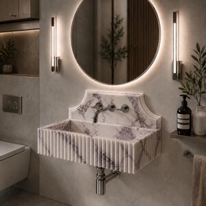 Luxury handcrafted Calacatta Viola marble floating wall mounted bathroom sink with sculptural fluted front and architectural backsplash in a premium designer bathroom.