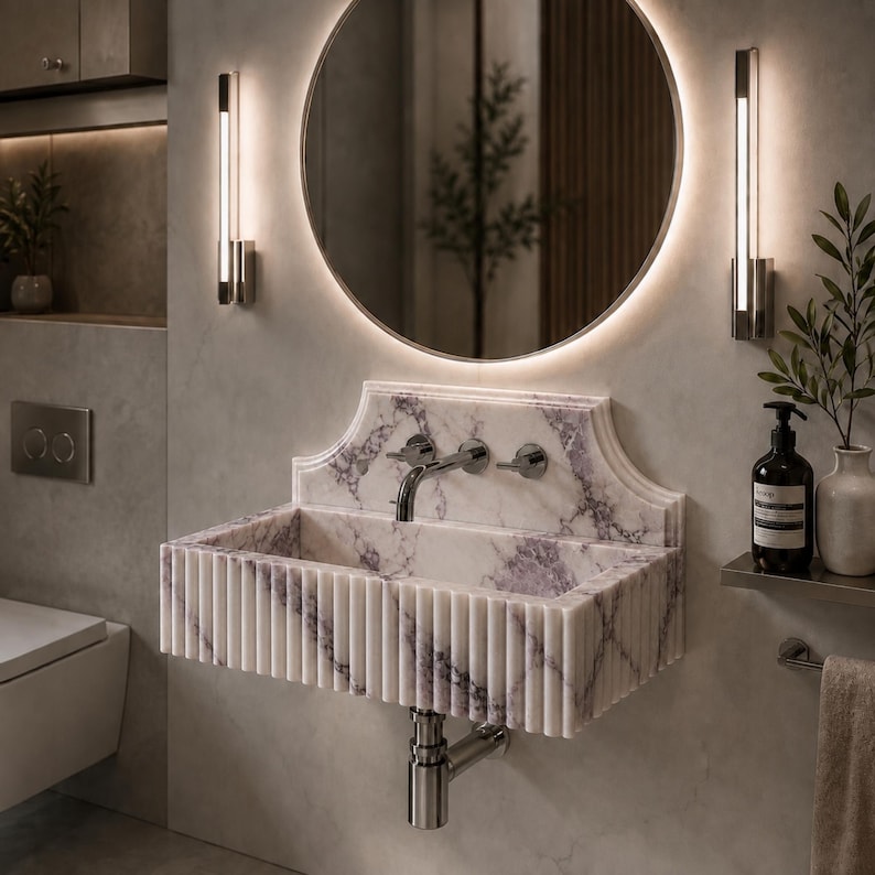 Luxury handcrafted Calacatta Viola marble floating wall mounted bathroom sink with sculptural fluted front and architectural backsplash in a premium designer bathroom.
