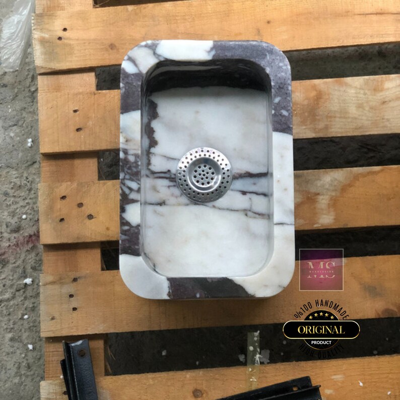 Top-down view of the rectangular Calacatta Viola marble sink highlighting the smooth basin interior, drain and unique veining.