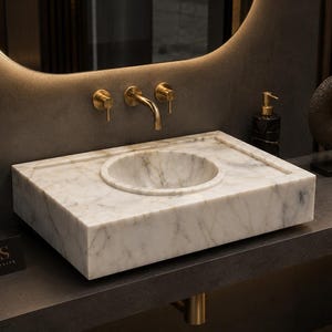 Raw Calacatta marble block arriving at the stone workshop, lifted by crane and prepared for cutting into a luxury handmade bathroom sink