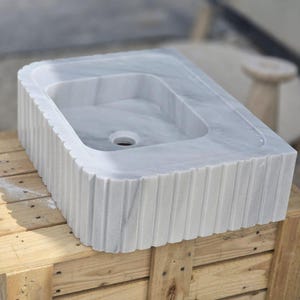 Elegant Bathroom Sink - Hand-Carved White Marble Bathroom Sink – Wall-Mounted or Countertop, Rectangular Vessel, Customizable Design - Close up of polished white marble sink bowl carved from a single block of natural stone ideal for modern and minimalist vanity designs