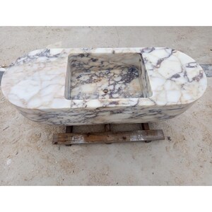 Luxury floating marble sink handcrafted from rare Calacatta Viola marble, suspended bathroom vanity basin designed for villas, penthouses and luxury homes, sculptural stone sink carved from a 2 ton marble block, architectural designer sink suspended with steel chains creating a stunning centerpiece for modern luxury bathrooms