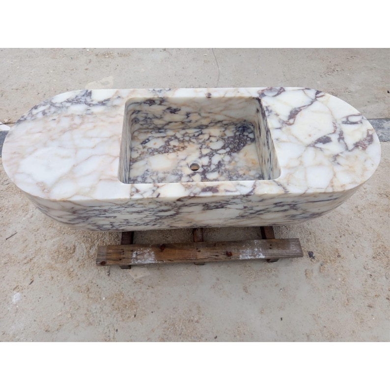 Luxury floating marble sink handcrafted from rare Calacatta Viola marble, suspended bathroom vanity basin designed for villas, penthouses and luxury homes, sculptural stone sink carved from a 2 ton marble block, architectural designer sink suspended with steel chains creating a stunning centerpiece for modern luxury bathrooms
