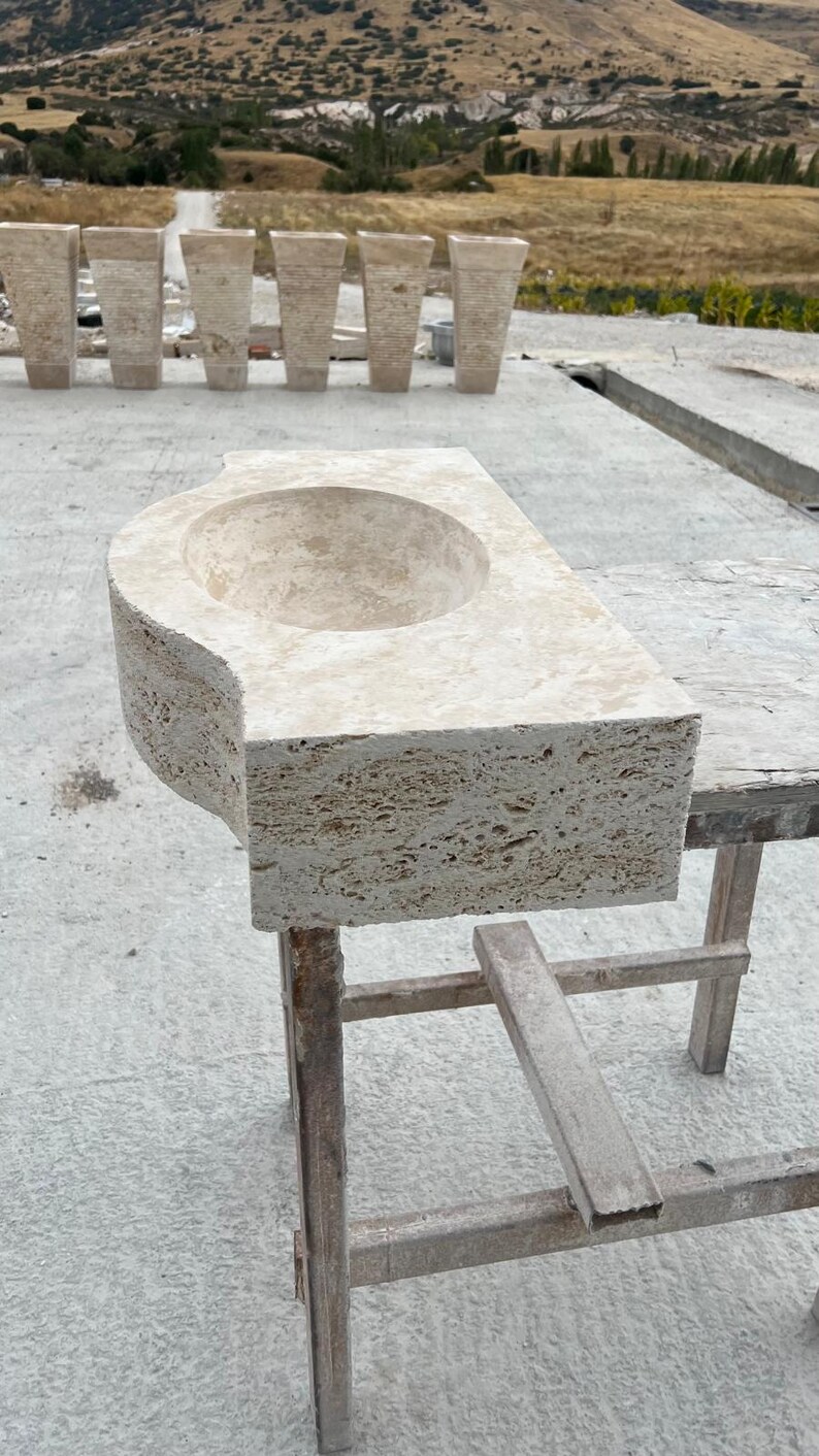 Hand-carved rectangular beige travertine countertop vessel sink with a smooth honed basin, rough chiseled exterior, centered drain and single faucet hole, custom-size natural stone bathroom washbasin by MarbleSinkCo.